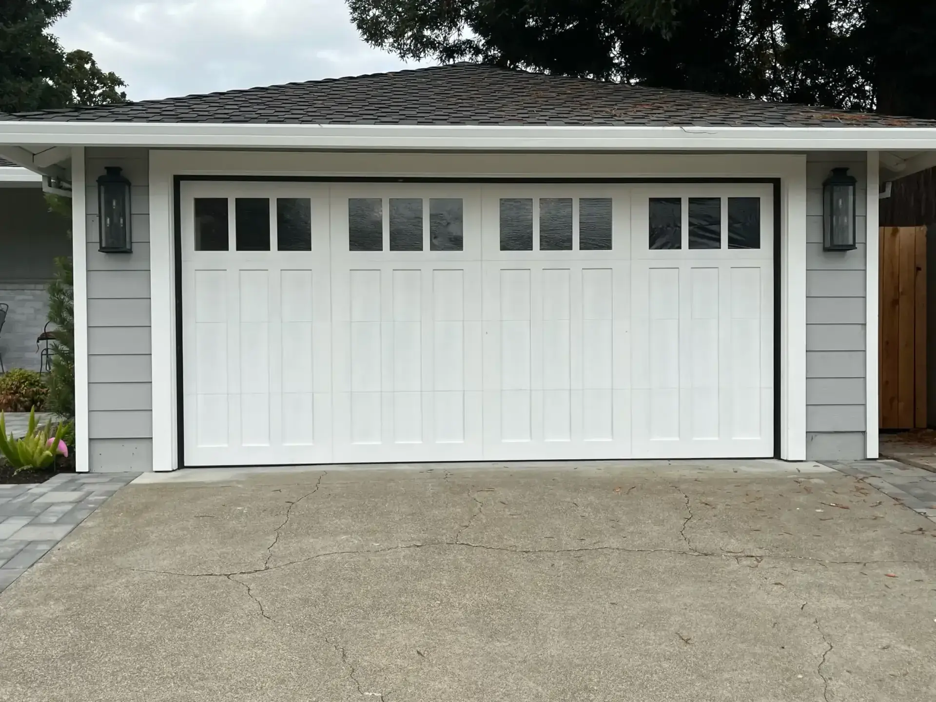 Professional installer working on residential garage door installation highlighting cost considerations